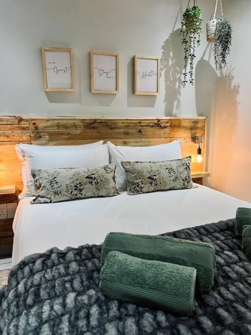 - une chambre avec un grand lit blanc et des oreillers dans l'établissement Wild Olive 91, à Windhoek