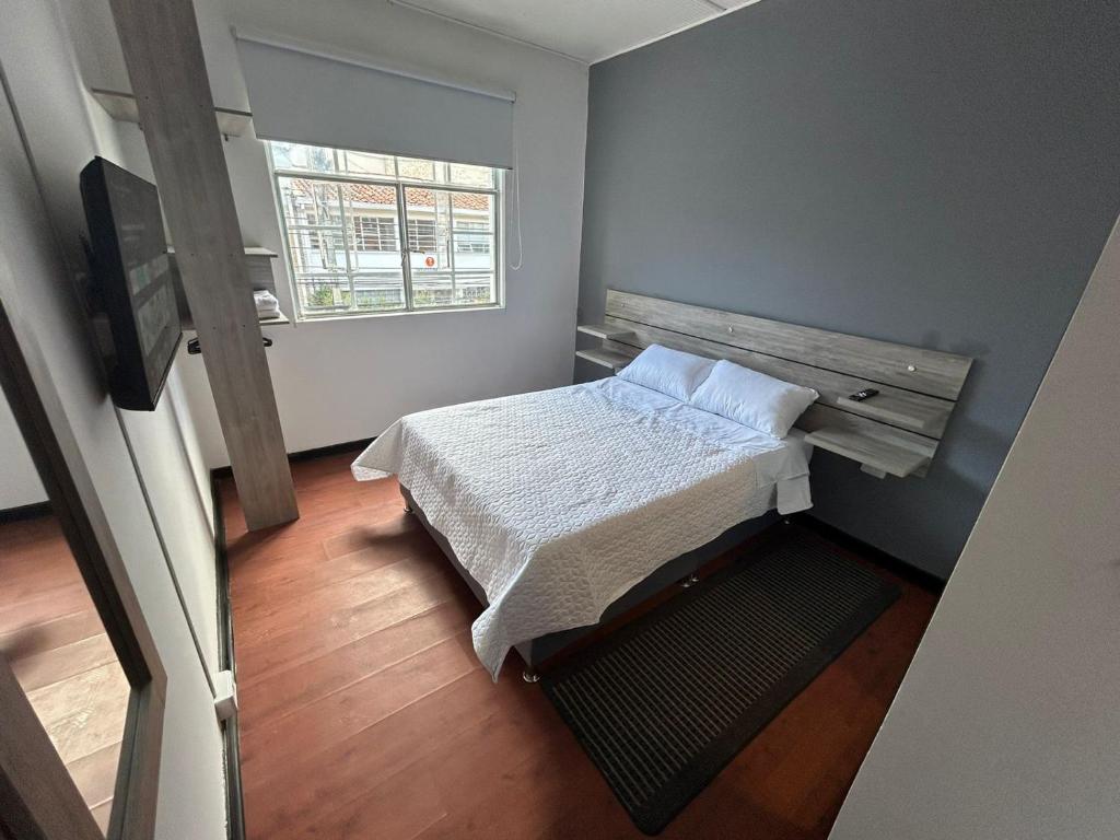 ein kleines Schlafzimmer mit einem Bett und einem Fenster in der Unterkunft Hostel Quinta Camacho in Bogotá