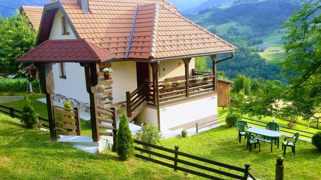 ein kleines Haus auf einem Hügel mit einem Tisch und Stühlen in der Unterkunft Kuca za odmor Drina & Tara in Bajina Bašta
