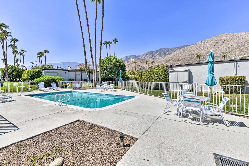 una piscina con sillas, una valla y un edificio en Palm Springs Condo with 2 Community Heated Pools!, en Palm Springs