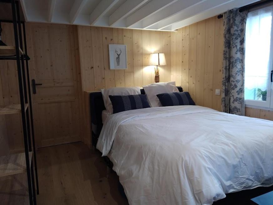 a bedroom with a large white bed with a window at Les gîtes d'Alex n°2 in Quend