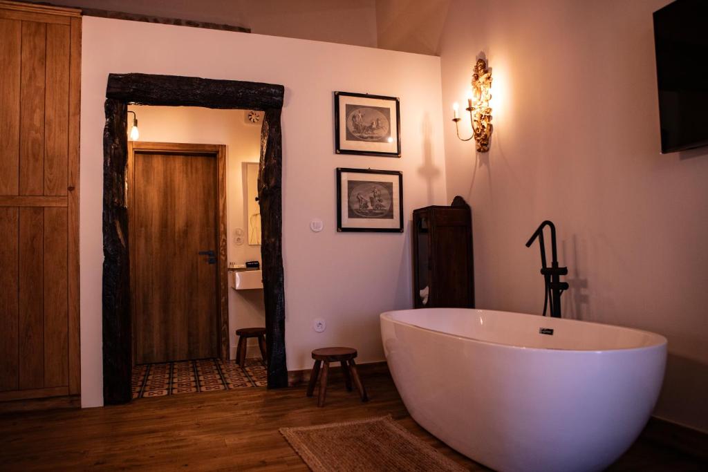 uma casa de banho com uma grande banheira branca num quarto em Quinta de São Francisco Houses em Viseu