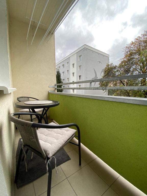 a balcony with two chairs and a table and a building at AR Comfort House in Košice