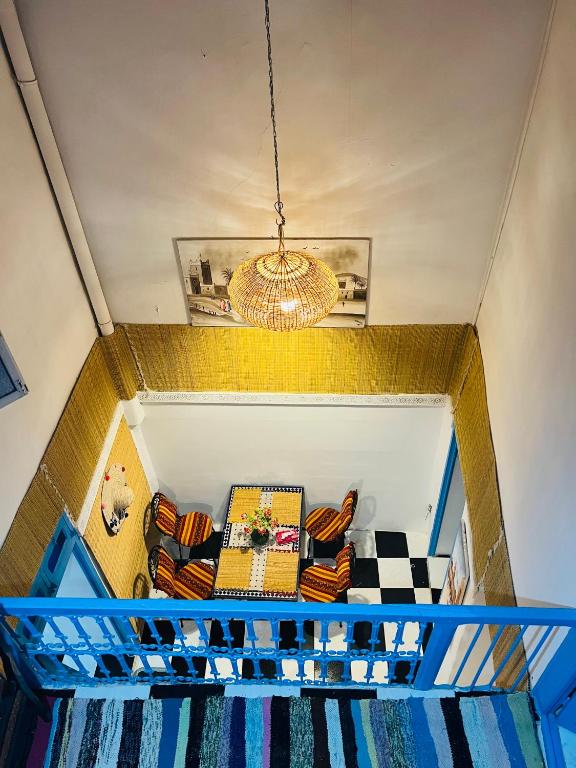 un soggiorno con divano e lampadario pendente di Dar Beldi a Marrakech