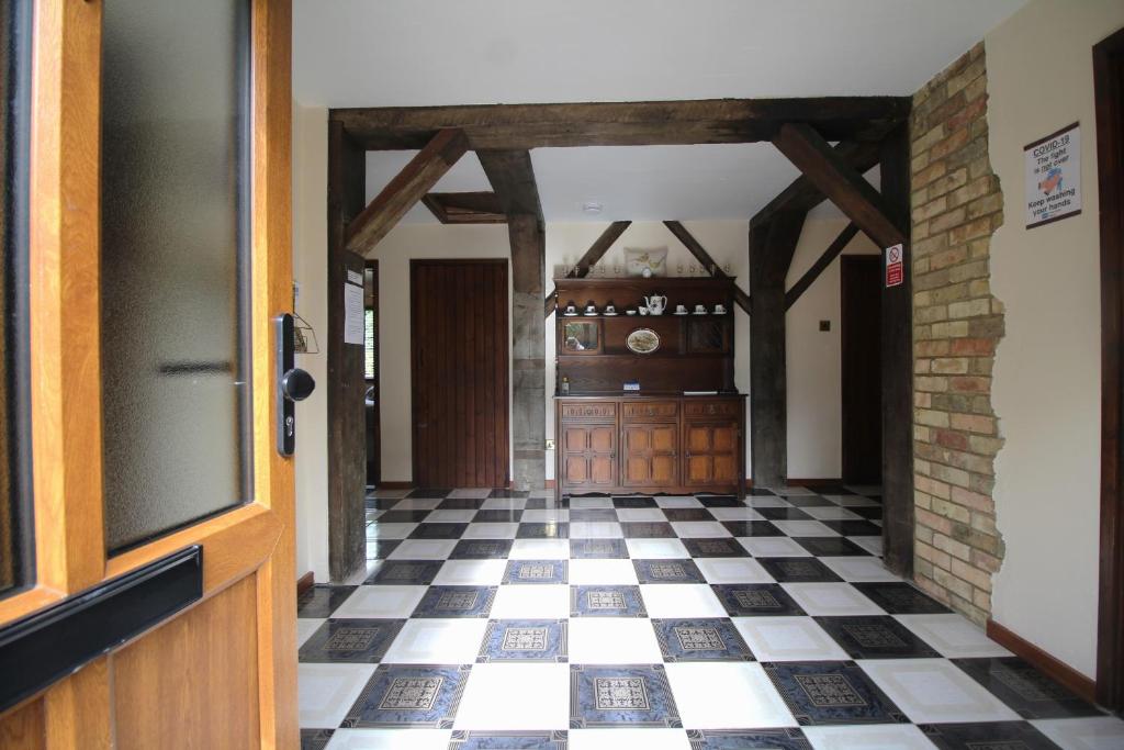 - un couloir avec un sol en damier noir et blanc dans l'établissement Highfields Holidays bed & breakfast, à Peterborough