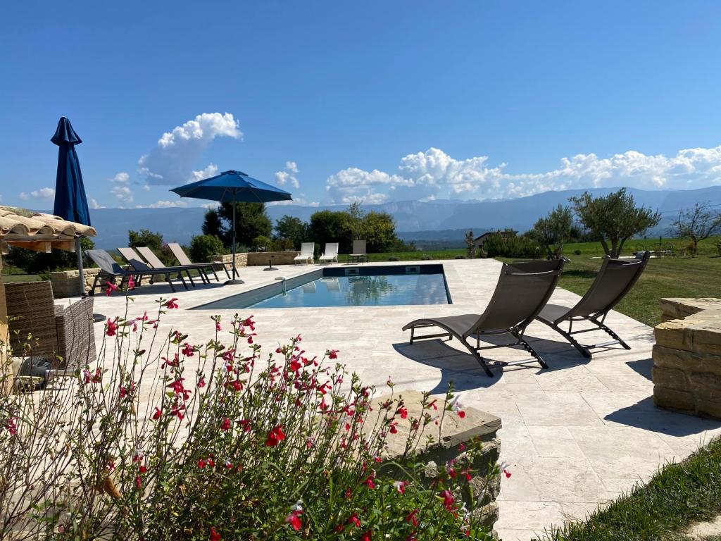 un patio con 2 sedie e una piscina di Gites&chambres d hôtes Les granges du Fournel a Saint-Lattier