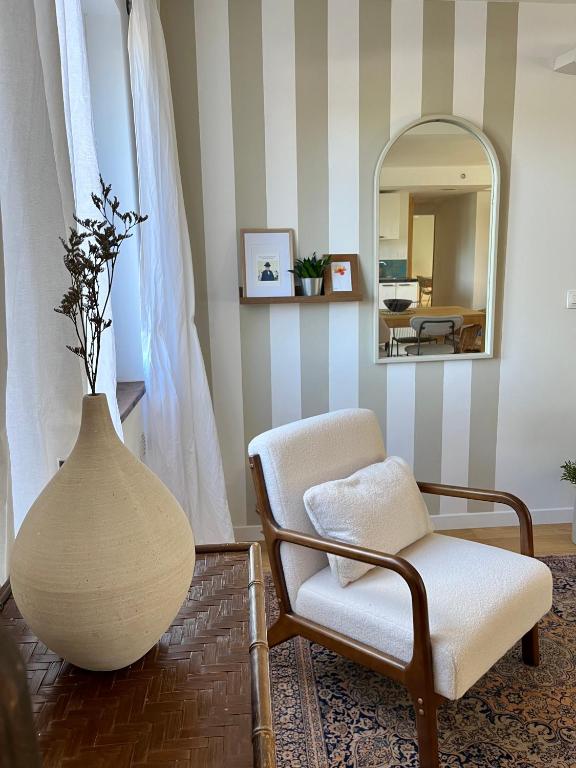 - un salon avec un vase, une chaise et un miroir dans l'établissement Le Pistachier - Maison cozy avec jardin privatif, à Saint-Jean-de-Védas