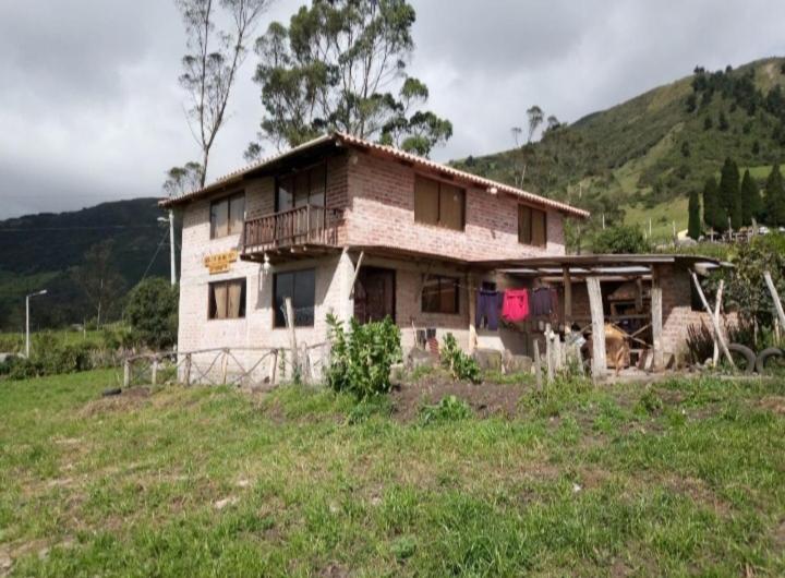an old house on a hill in a field at MIRADOR MAMÁ NATY Y SUS NEGUITOS in Chambo