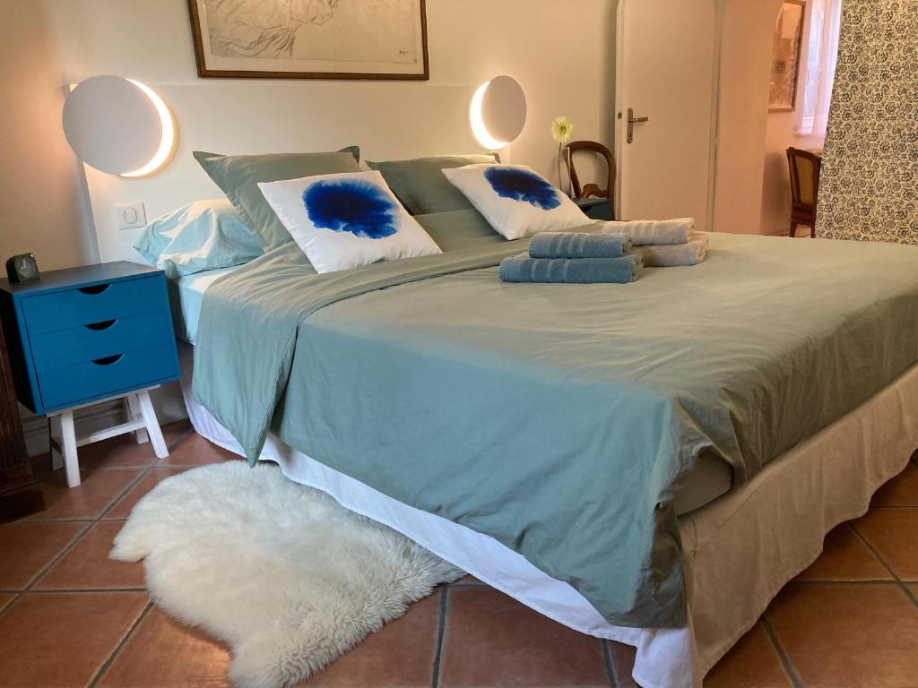 a bedroom with a large bed with blue pillows at Le Rez de Jardin in Illkirch-Graffenstaden