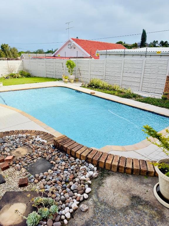 a swimming pool with rocks around it in a yard at Apartment on Liddiard in East London