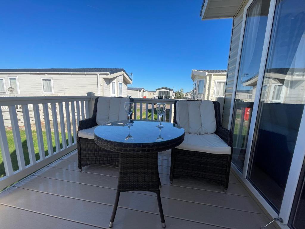 a patio with a table and chairs on a balcony at Whitstable serenity in Whitstable