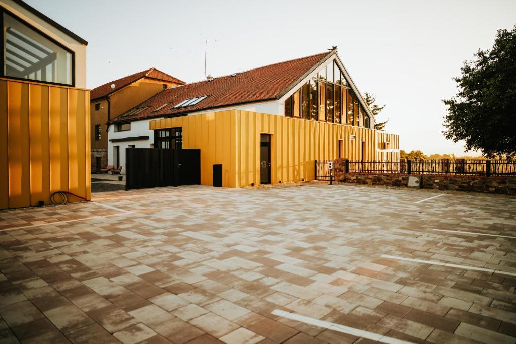 una iglesia con un edificio amarillo con patio en Galerie mlýn Žeraviny 