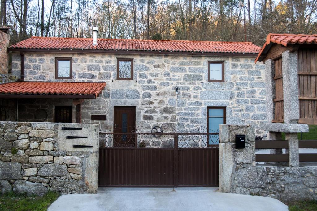 ein Steinhaus mit einem Tor davor in der Unterkunft A CASA DA MOREIRA - Casa rural en Ponte Maceira in A Coruña