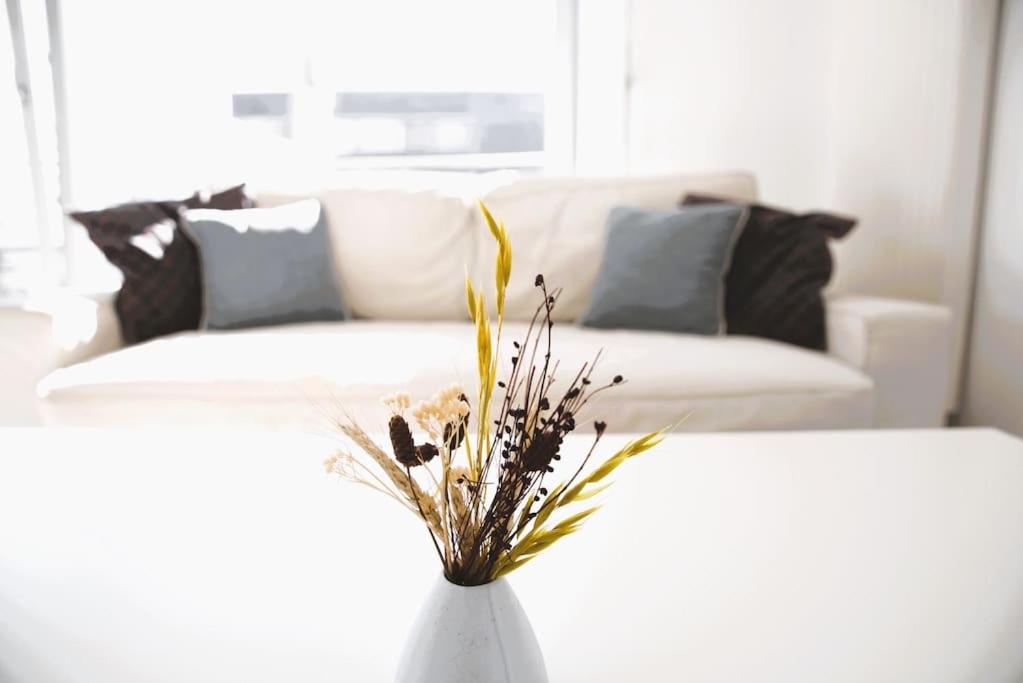 uma sala de estar com um sofá e um vaso com flores em Lovely Modern 1 BR apartment em Luxemburgo