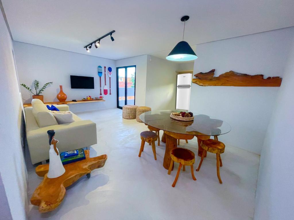 a living room with a table and a couch at Flat Pingo de Milagres in São Miguel dos Milagres