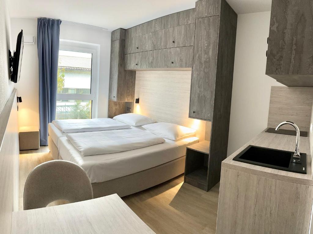 a hotel room with a bed and a sink at Apartimo München-Unterhaching in Unterhaching