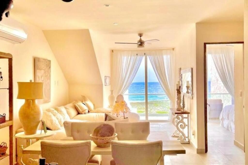uma sala de estar com um sofá e vista para o oceano em Casa Blanca By The Caribbean Sea em Akumal