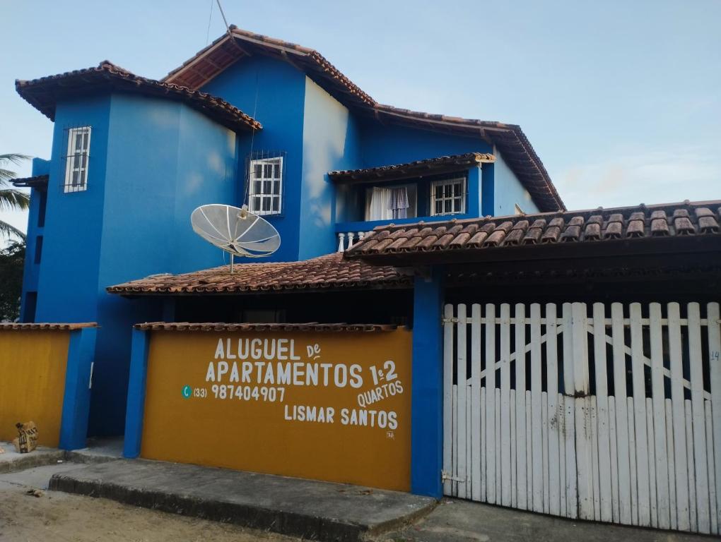 a blue house with a white fence at Residencial Santos in Nova Viçosa