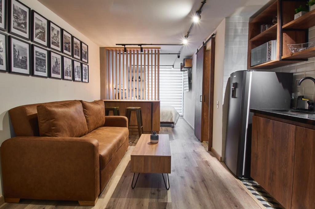 Una sala de estar con un sofá y un refrigerador. en Torre Ventto Loft 529, en Bogotá