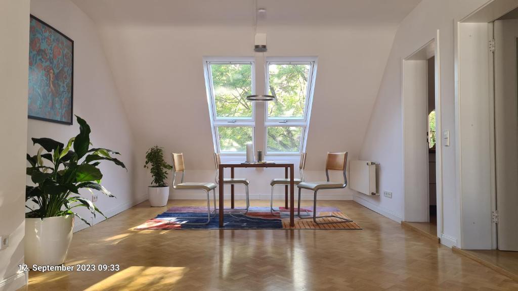 ein Esszimmer mit einem Tisch, Stühlen und einem Fenster in der Unterkunft Modernes Apartment mit 3 Zimmern in Karlsruhe