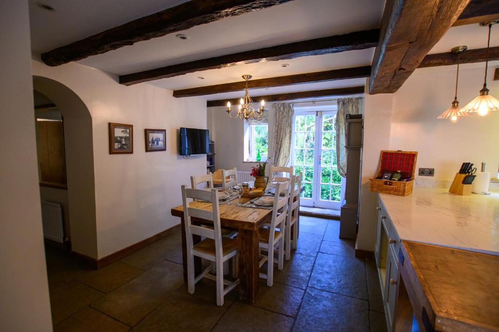 a kitchen and dining room with a table and chairs at The Farthings Cotswolds Holiday Cottage in Chipping Campden