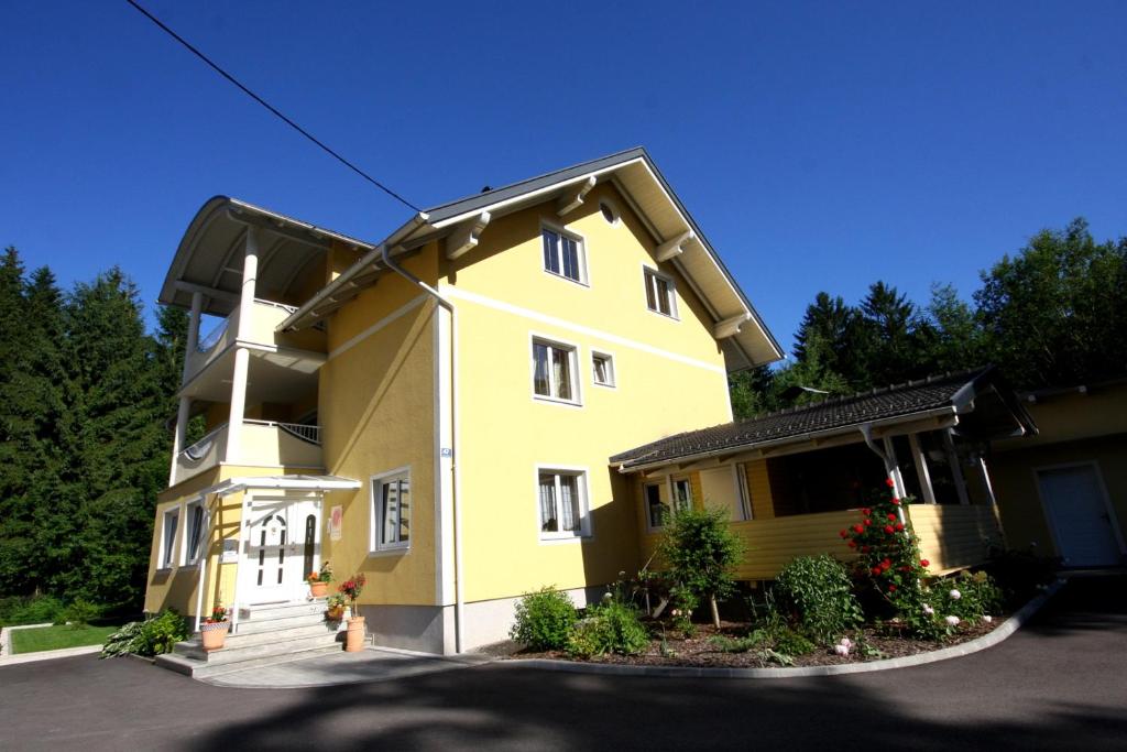 uma casa amarela com muitas janelas em Appartements Flor em Wasserhofen