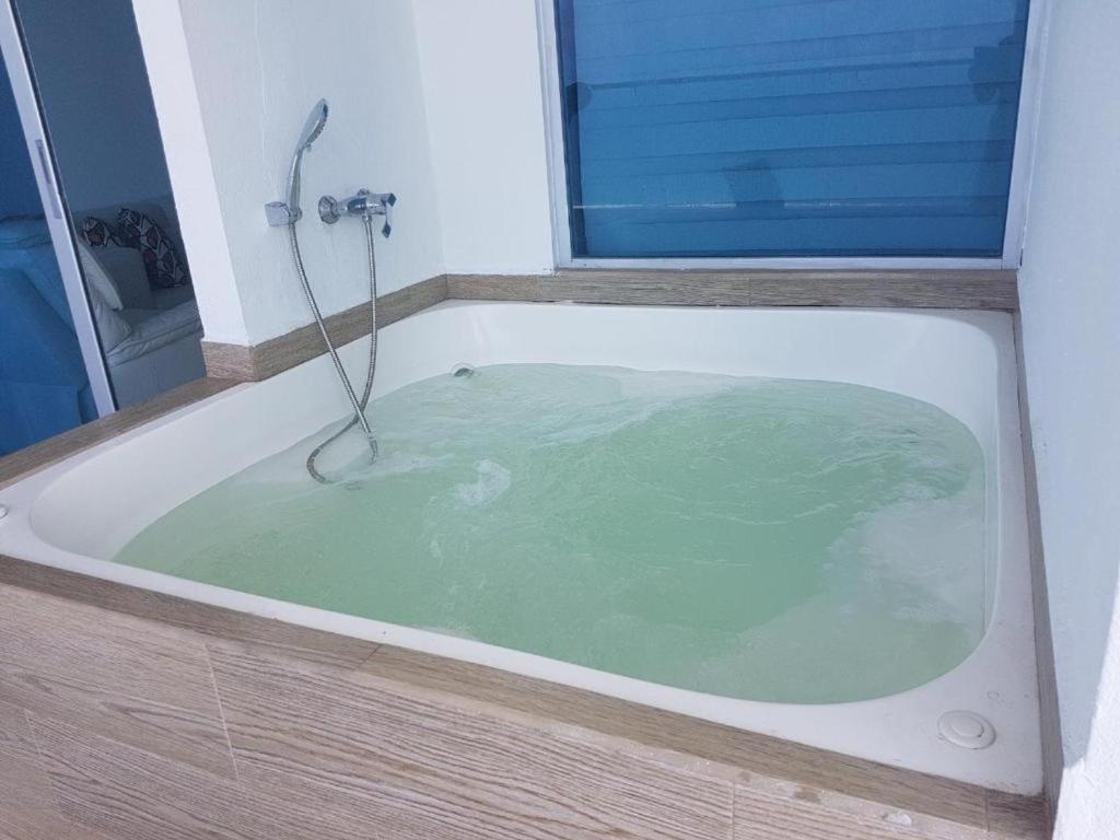 朵索巴的住宿－Grand Diamond Beach (TONSUPA)，浴室设有装满水的浴缸。