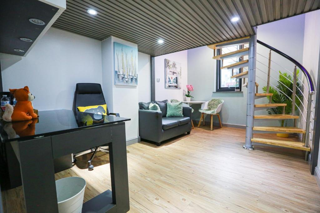 een kamer met een trap, een stoel en een tafel bij B103 Urban Oasis loft in Coventry
