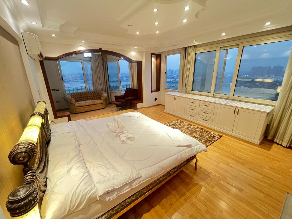 a bedroom with a large bed in a room with windows at Luxury Villa By The Nile in Cairo