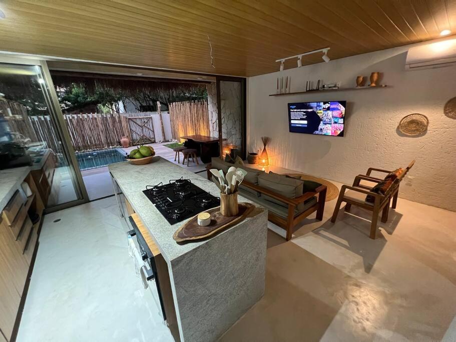 a kitchen and living room with a stove and a couch at Villa Jucá Casa 03 in Pôrto de Pedras