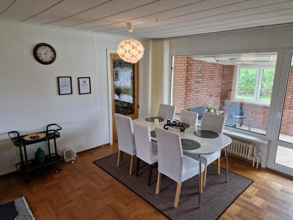 a dining room with a table and chairs and a clock at Villa med egen parkering. Möjlighet att boka från 1 och upp till 5 personer. in Örebro
