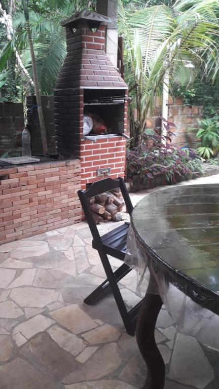 um forno de tijolos com uma mesa em frente em Casa de Temporada no Paraíso Guaraú em Peruíbe