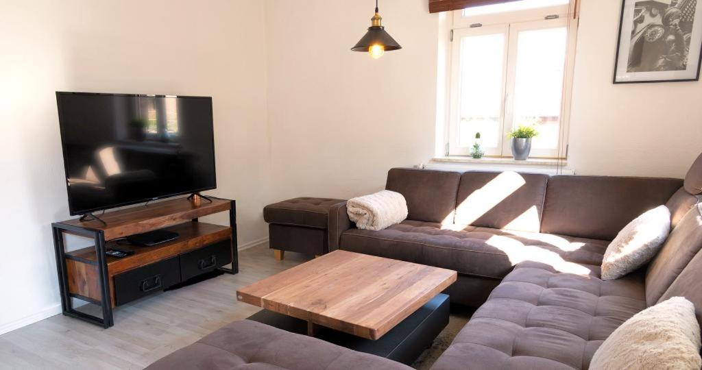 a living room with a couch and a flat screen tv at Schuster Bude in Münchhausen