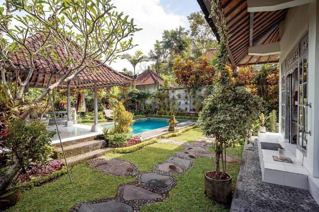 einen Hinterhof mit einem Pool und einem Haus in der Unterkunft BREATHE in @ Villa GAIA / PRIVATE Pool UBUD in Ubud