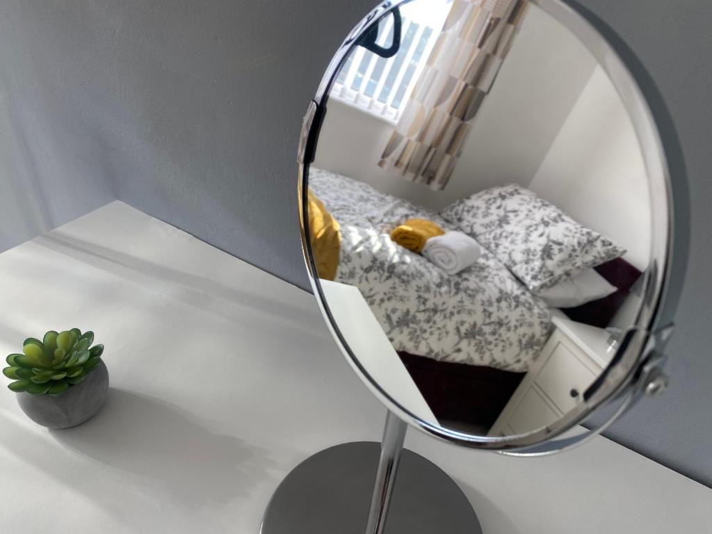 een spiegel op een tafel met een bed in een kamer bij Howard’s House, Home from Home in Thornaby on Tees