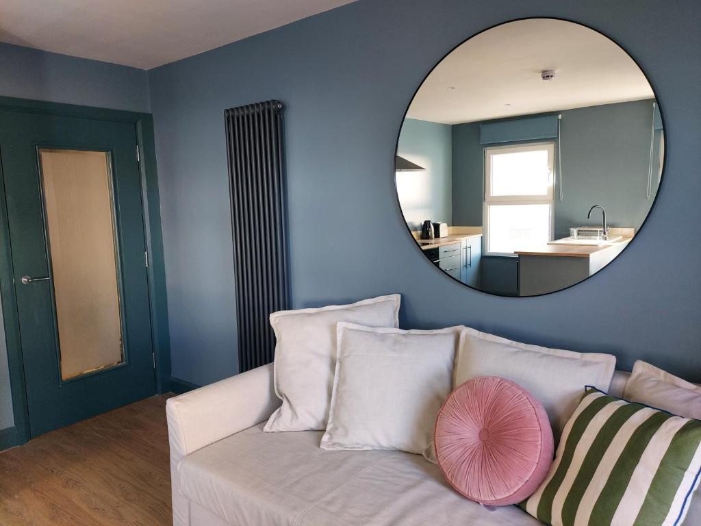 a living room with a white couch and a mirror at Cathedral Quarter Apartments in Derry Londonderry