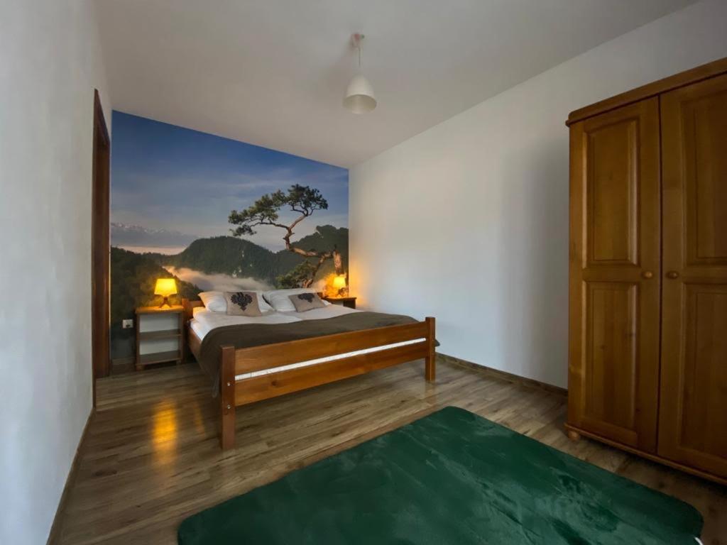 a bedroom with a bed with a painting on the wall at Krokus in Sromowce Niżne