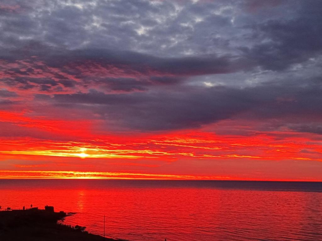 a sunset over the ocean with a red sky at B&B Antico Porto Tarquinia in Tarquinia