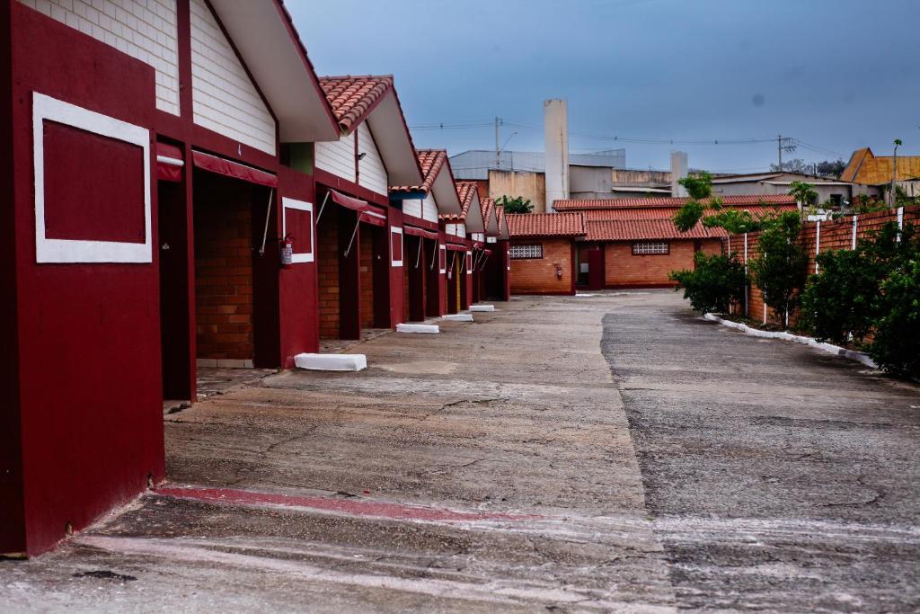 a row of red buildings on a street at Hotel e Motel Madrugada in Itu