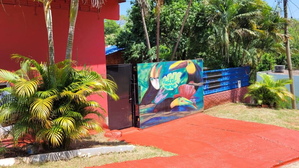 a gate with a painting on it next to a building at Hostel Haus in Puerto Iguazú