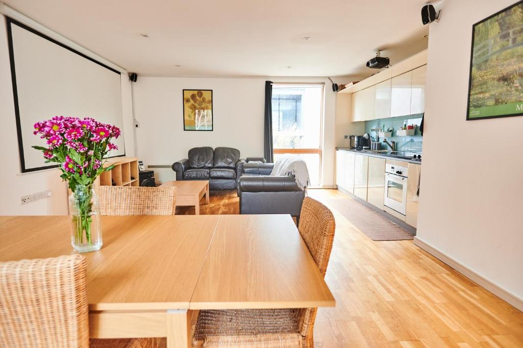 eine Küche und ein Wohnzimmer mit einem Tisch und Stühlen in der Unterkunft Apartment in old street in London