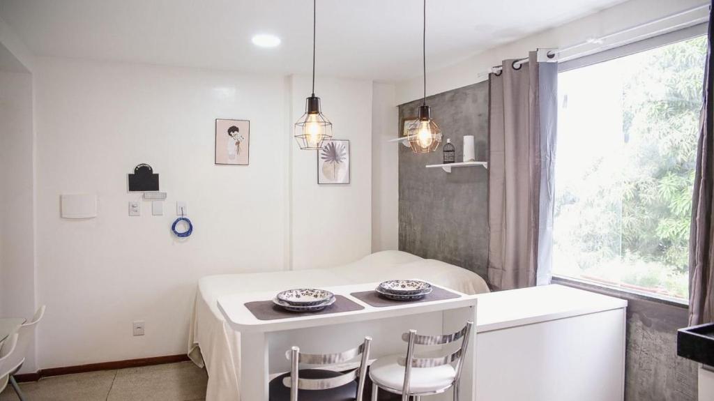 a white kitchen with a table and two chairs at STUDIO 301 | WIFI 600MB | RESIDENCIAL JC, um lugar para ficar. in Belém