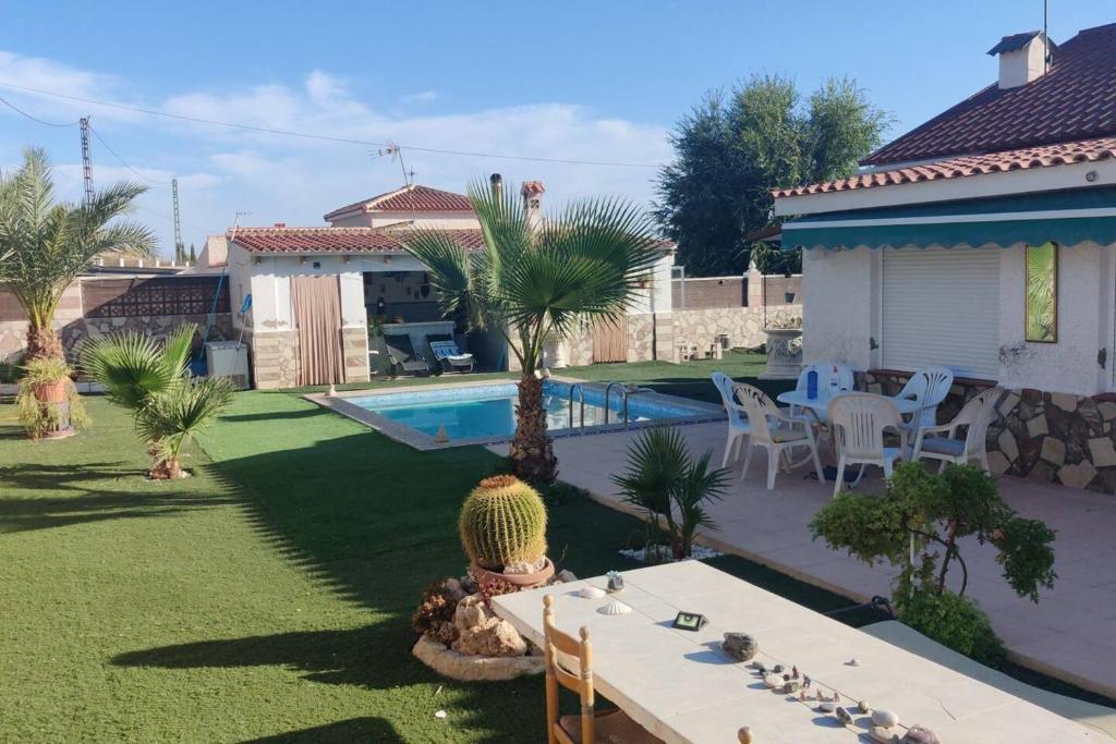 a backyard with a table and a swimming pool at Villa Noah in Moralet
