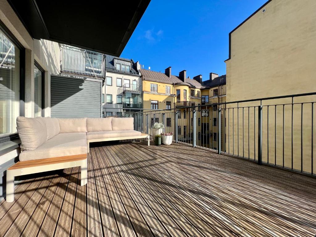 biała kanapa na balkonie z budynkami w obiekcie modern apartment with private terrace w Helsinkach