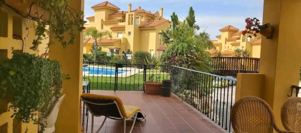 Un balcón con sillas, una valla y un edificio en Bienvenido a tu habitacion en Málaga