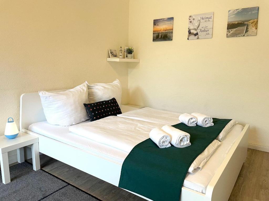 1 dormitorio con 1 cama con toallas en Frauenpreiss-Whg-47 en Cuxhaven