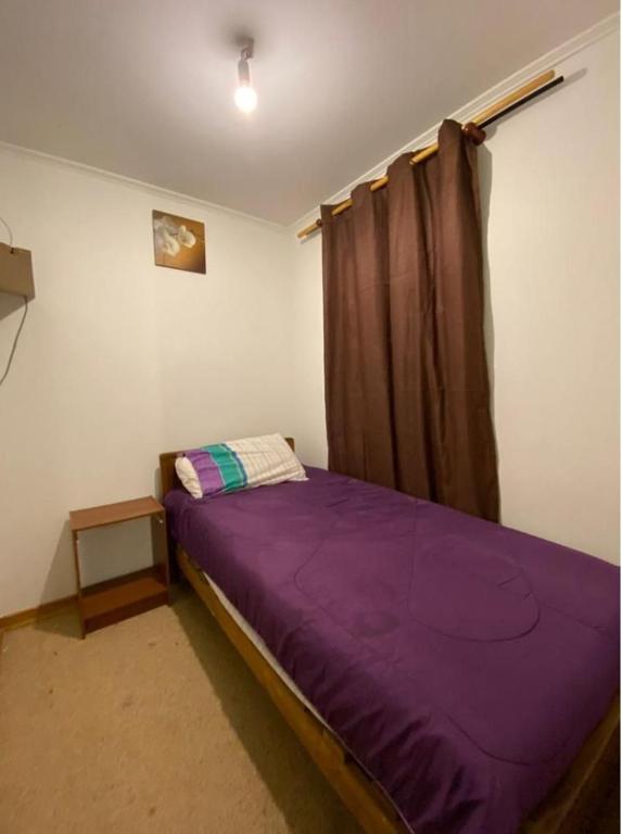 a bedroom with a purple bed and a window at Habitación casa condominio in Coquimbo