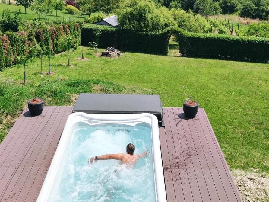 a man in a swimming pool in a backyard at Villa Wolf Castle - vanjski grijani bazen in Lopatinec