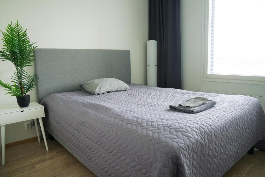 1 dormitorio con 1 cama con manta y planta en Lovely 2R apartment, en Oulu