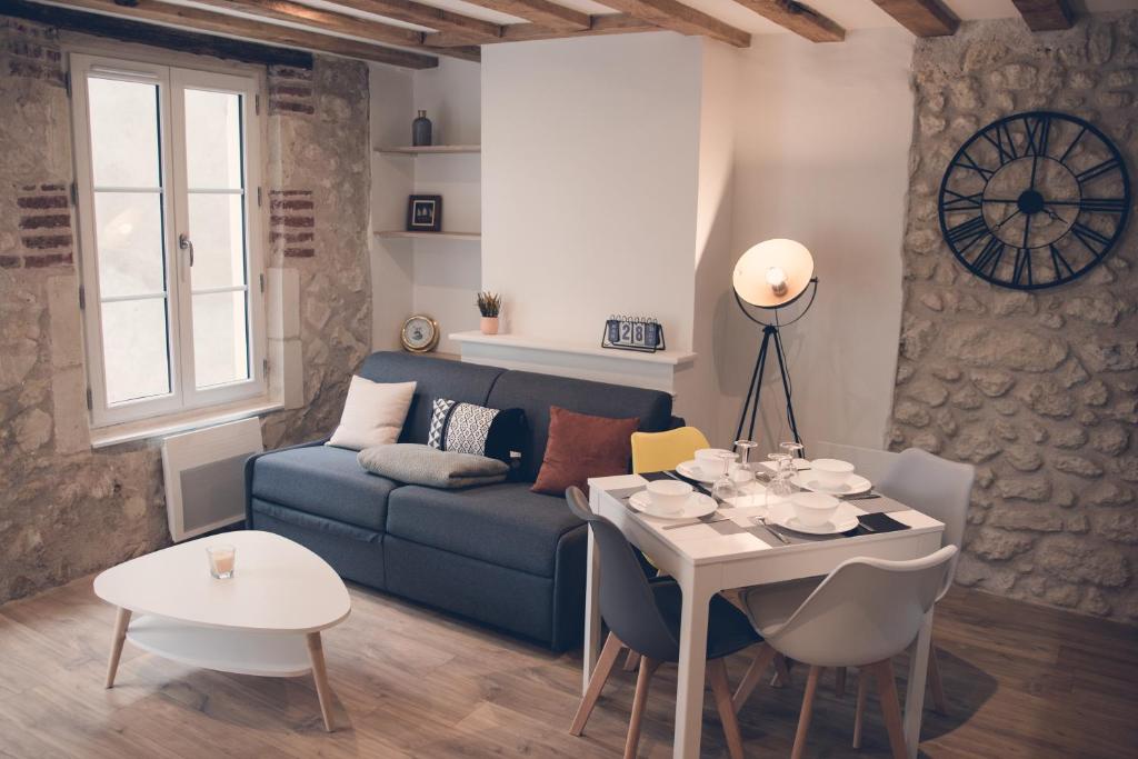 ein Wohnzimmer mit einem blauen Sofa und einem Tisch in der Unterkunft Les Belles Pierres - HyperCentre in Amboise